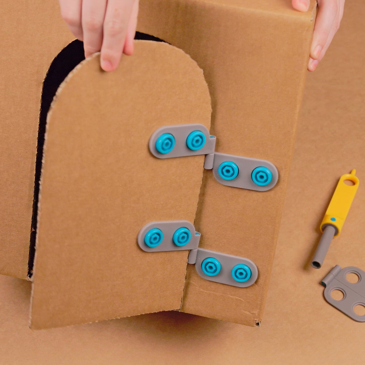 Twee Spin-Hinge-scharnieren bevestigen een deur aan kartonnen huis