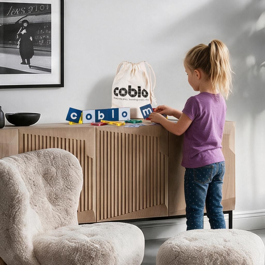 Kind speelt met Coblo Mini lettertoppers op een kast