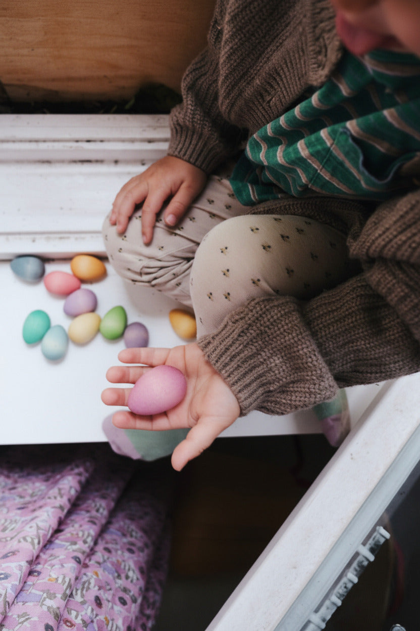 Kind verzamelt gekleurde Happy Eggs in een kleine mand