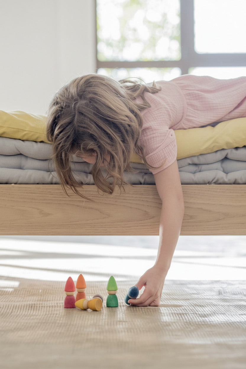 Kind speelt op de vloer met Grapat Rainbow Tomtens