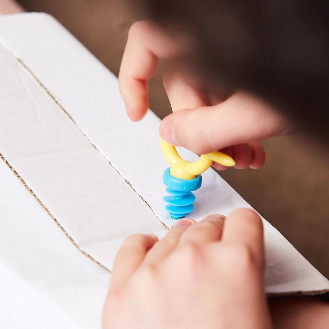 Hand draait blauwe Scru met gele Mini-Tool in wit karton