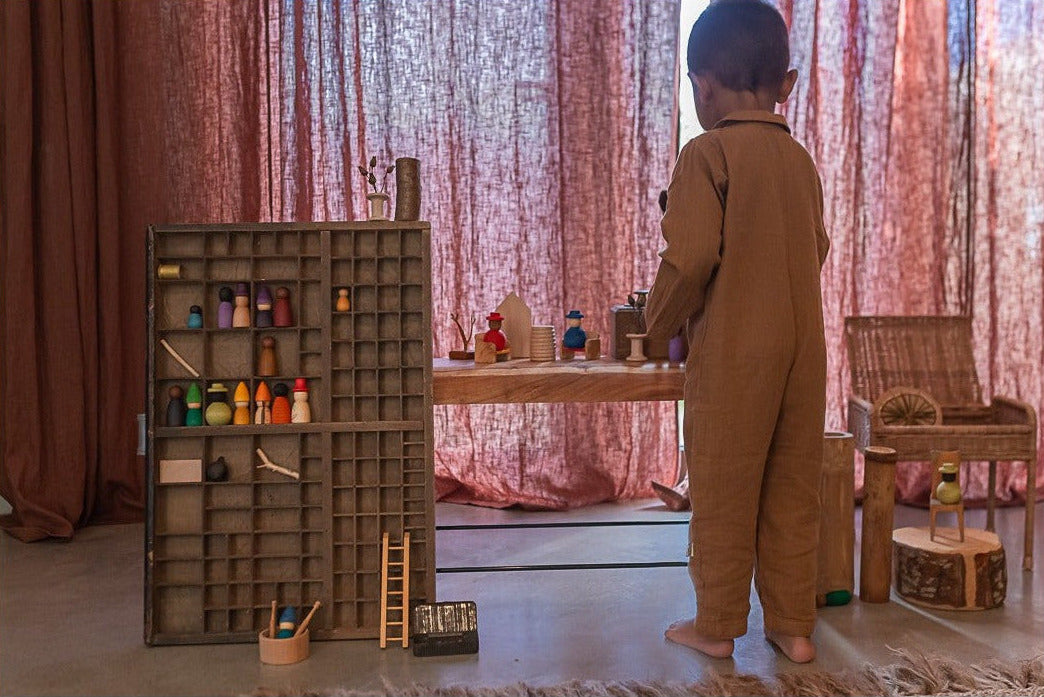 Kind zet Together Nins in een houten vakkenkast
