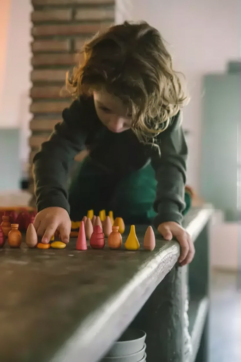 Kind maakt een rij met onderdelen van de Warm Mandala Mix