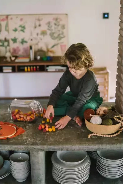 Kind speelt op de vloer met warme Mandala Mix vormen