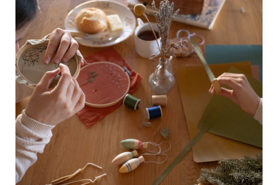 Handen rijgen Winter Sparkles ornamenten tijdens een knutselmoment
