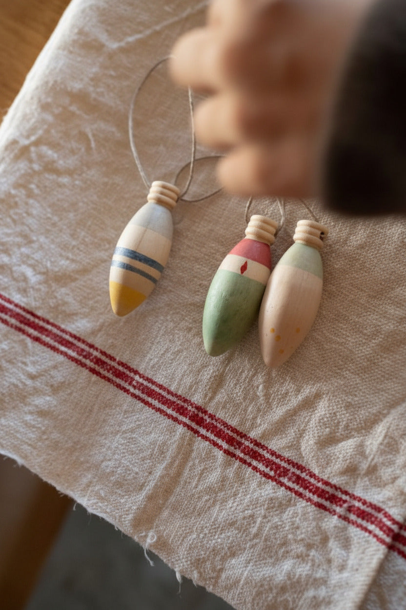 Kind hangt Winter Sparkles ornamenten aan rode draden